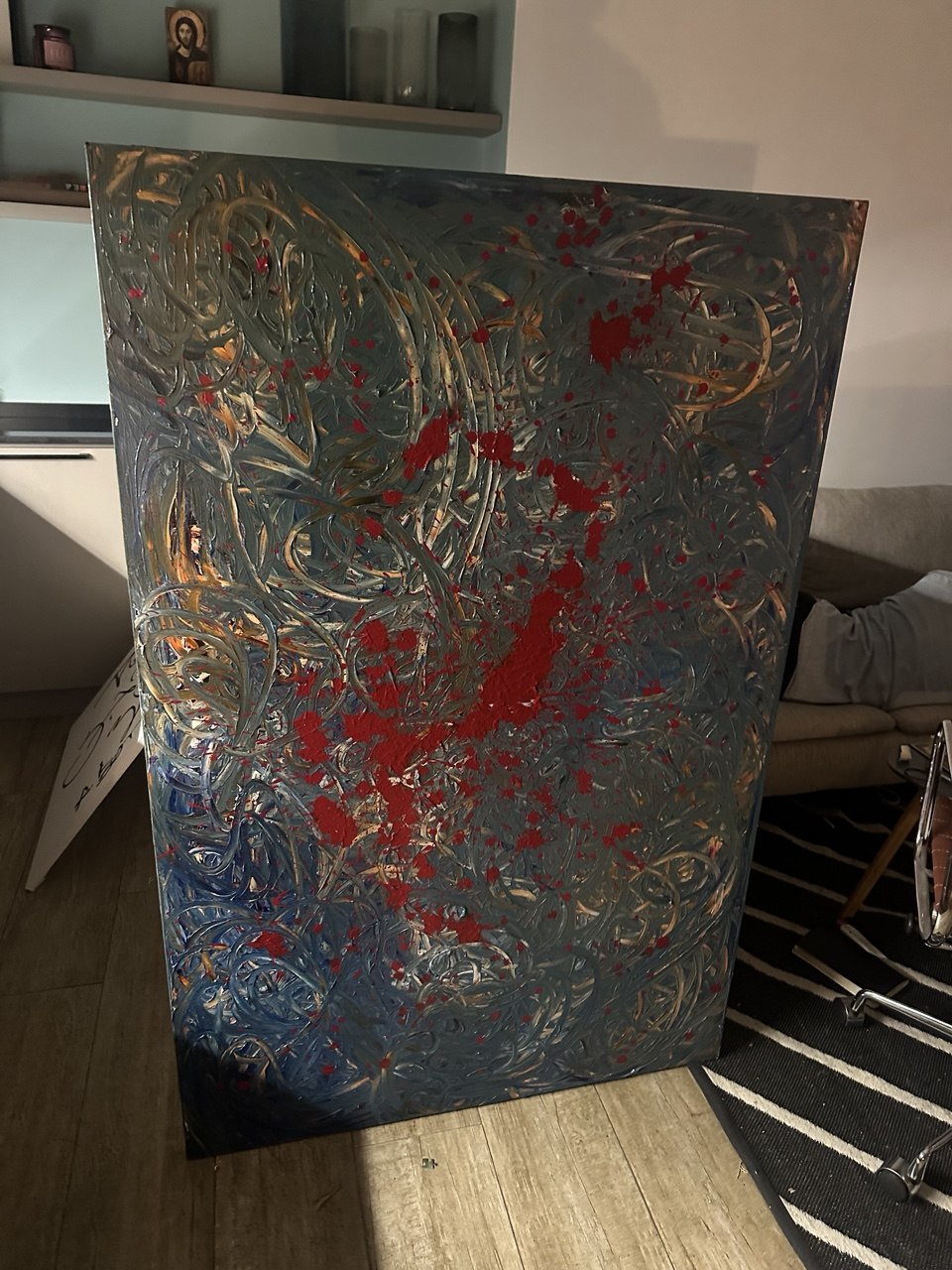 Grey and blue swirling abstract painting with red splashes