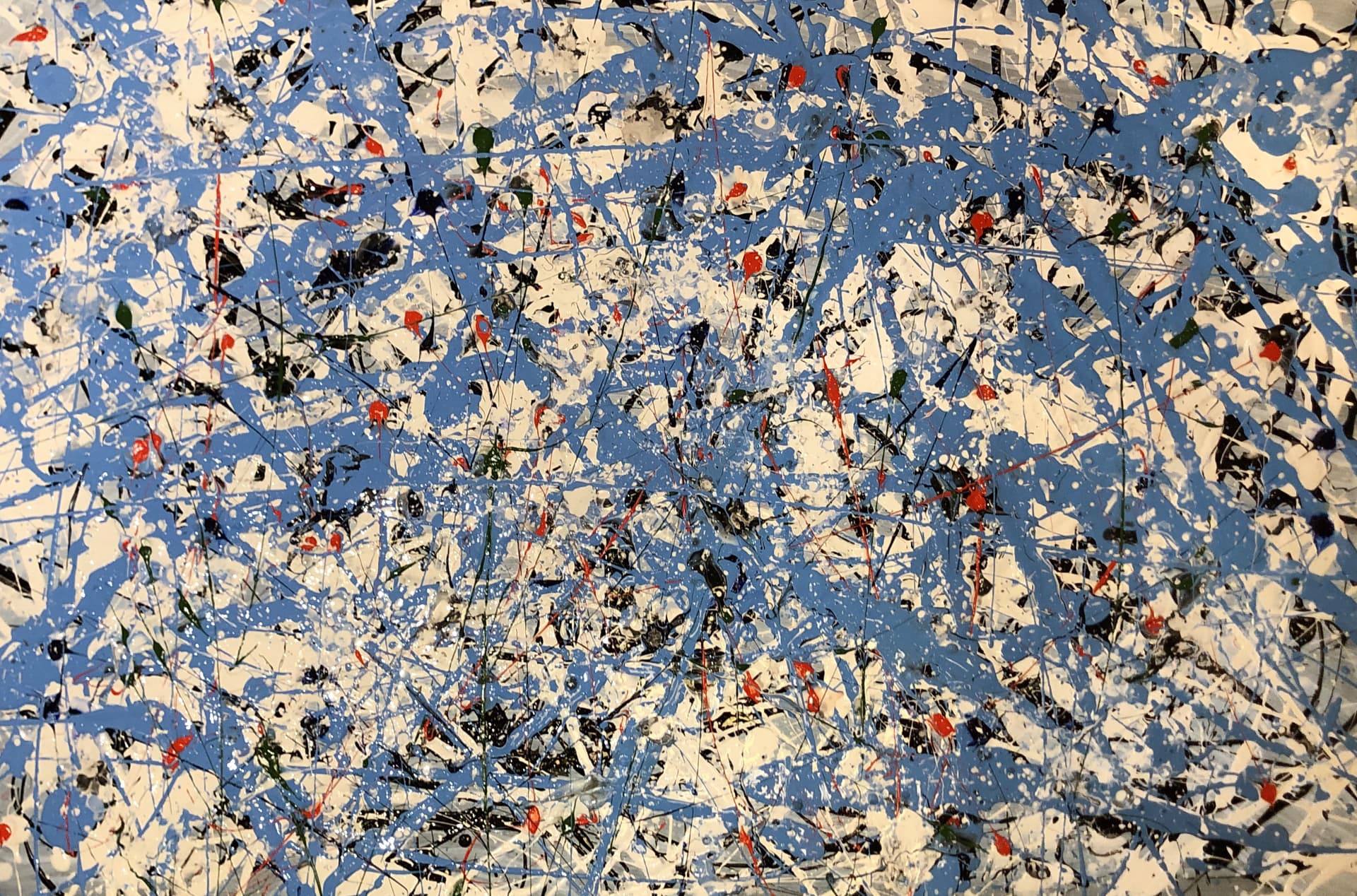 Energetic splatter painting in blue, white, red and black