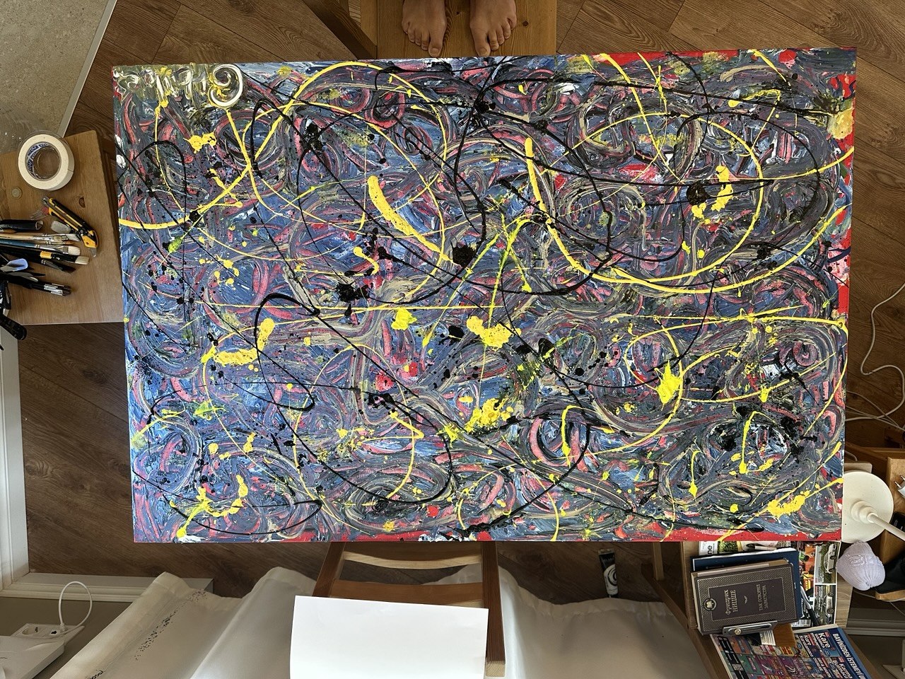 Colourful abstract canvas resting on the studio floor, seen from above